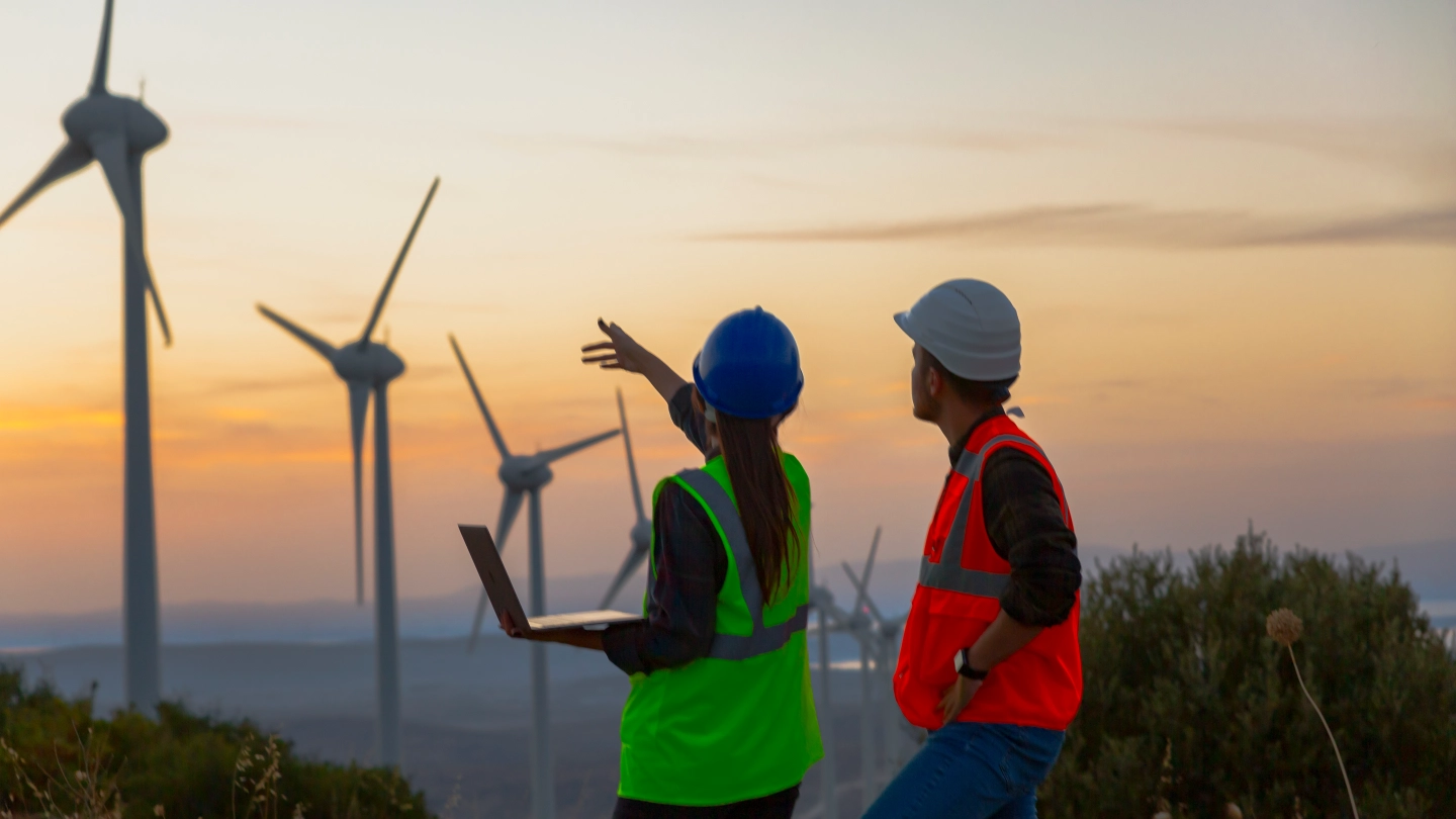 Two energy workers in front of wind turbines Solutions image