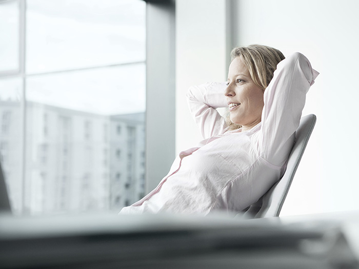businesswoman relaxing behind desk
